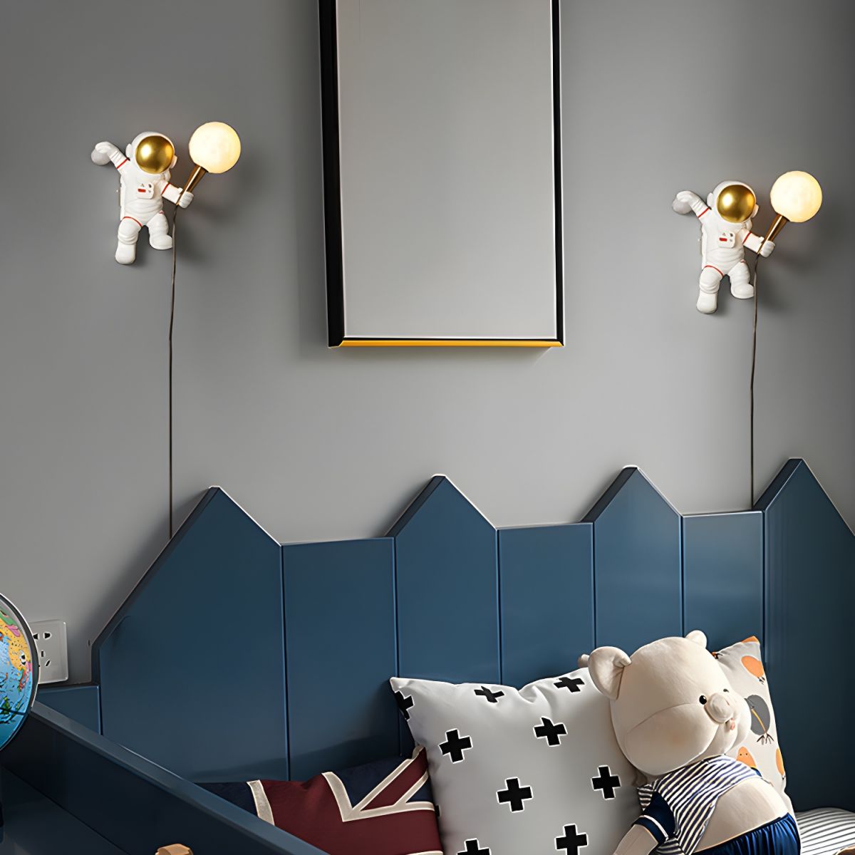 Astronaut wall lights with gold and white LED globes mounted on grey wall above blue geometric headboard in kids bedroom UK
