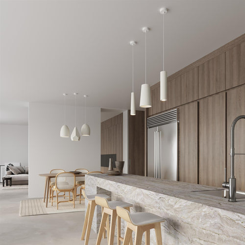 White ceramic cylindrical pendant lights hanging over marble kitchen island in modern minimalist interior