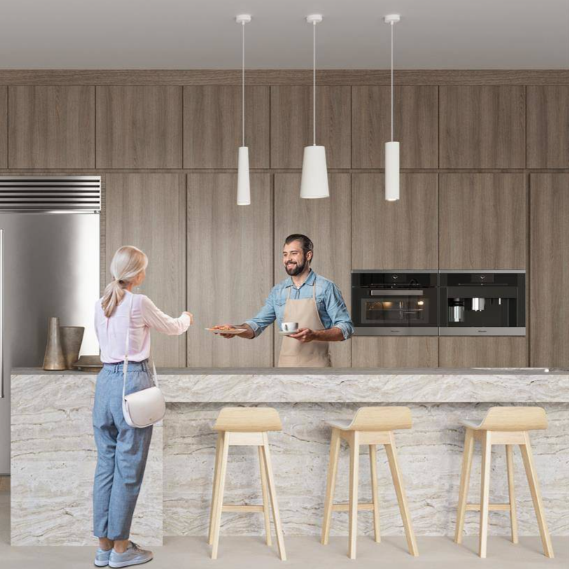 White ceramic pendant lamps hanging over modern kitchen island - minimalist cylindrical design with ceiling mounts