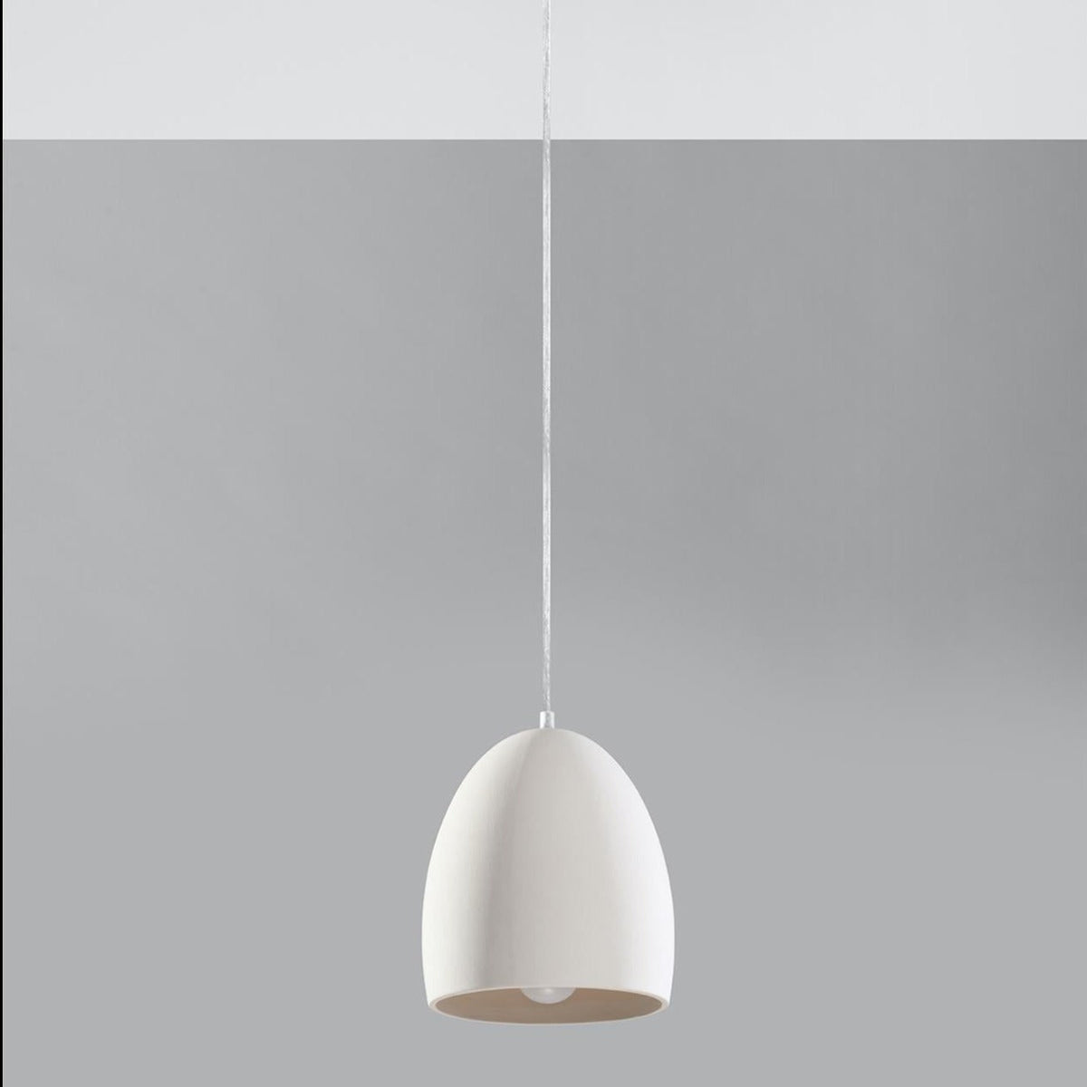 White ceramic dome pendant light with matte finish hanging from cord against grey background - UK lighting decor