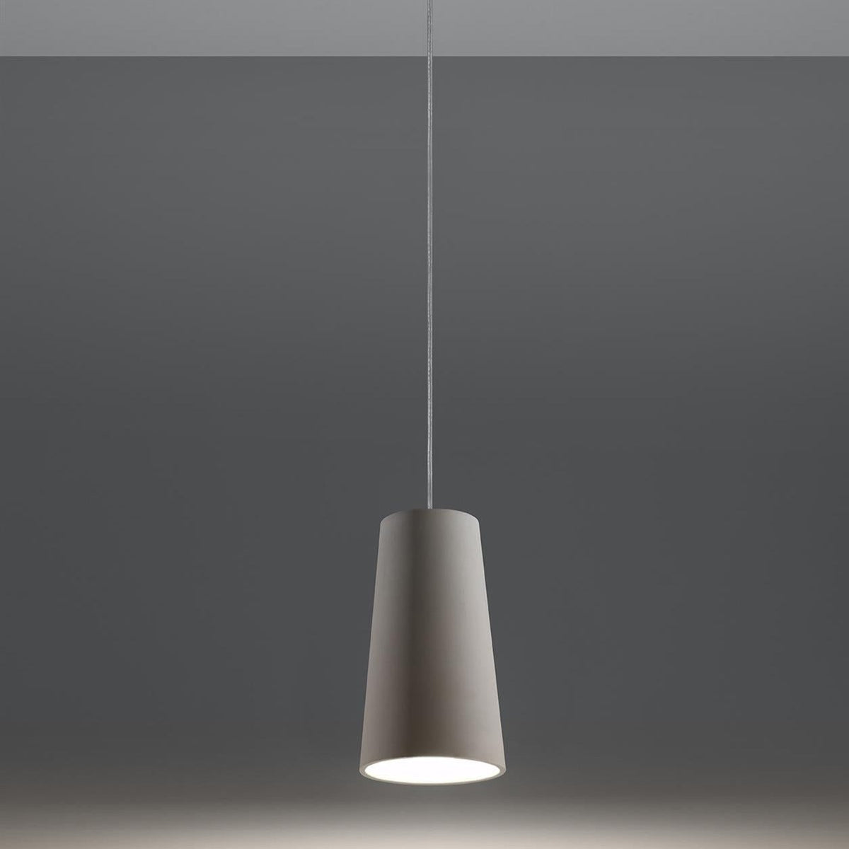 Grey ceramic conical pendant light with white interior, suspended by cable against neutral background - modern style