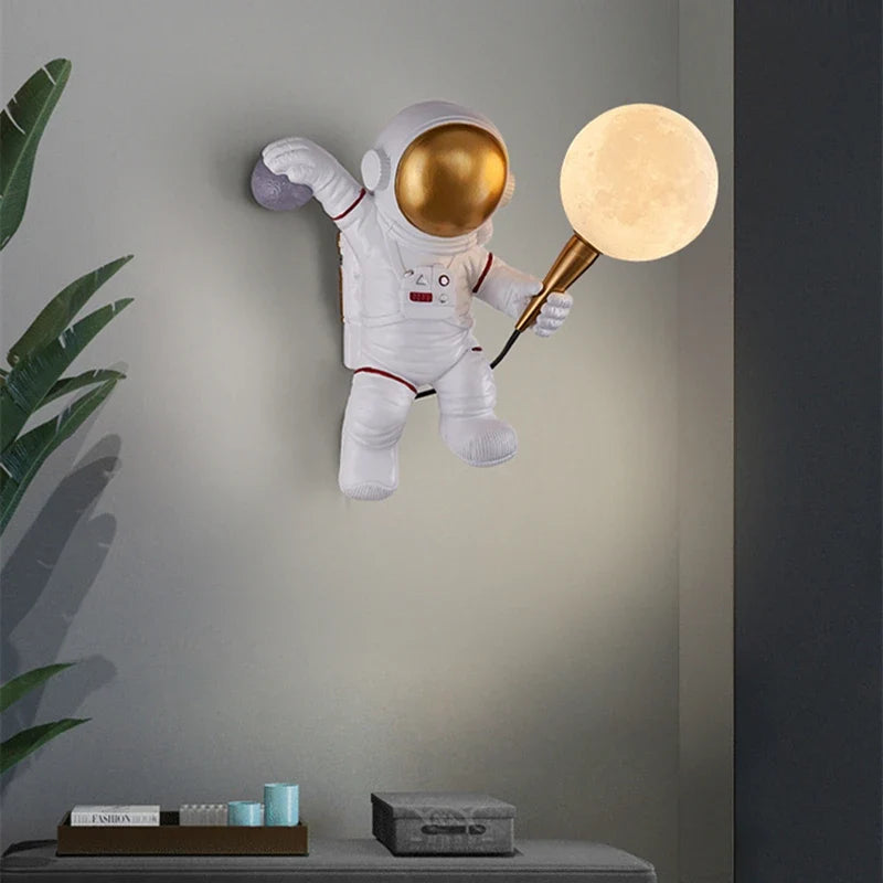 Astronaut wall light with warm white LED moon globe illuminated, mounted on grey wall in modern UK kids bedroom setting