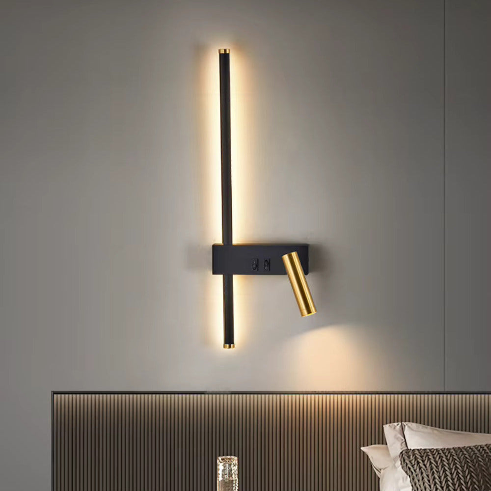 Modern black and brass LED wall light with vertical strip and adjustable reading lamp, warm white glow on bedroom wall