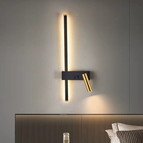 Modern black and brass LED wall light with vertical strip and adjustable reading lamp, warm white glow on bedroom wall