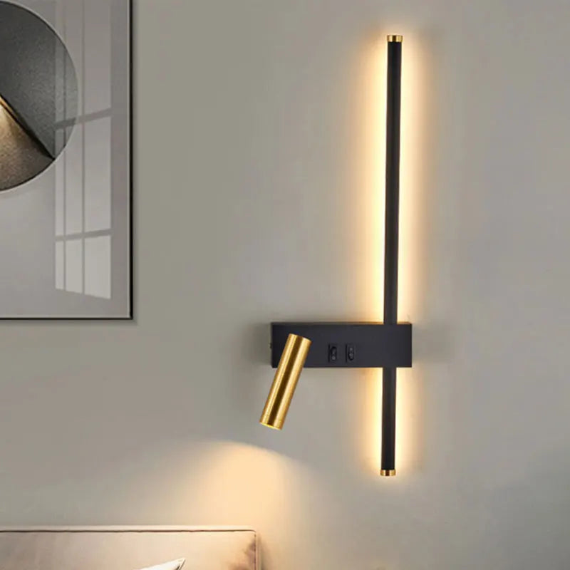 Modern black and gold LED wall lamp with vertical light strip and adjustable reading light, mounted on white wall